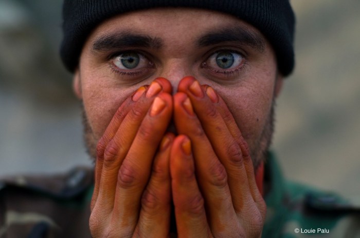 Still photography for documentary film Kandahar Journals. An Afghan soldier seen warming his henna stained hands from EID worship on the front lines in Zhari District, Afghanistan. (Credit Image: © Louie Palu) www.kandaharjournals.com For use in film reviews to do with Kandahar Journals only.
